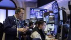 Trader Gregory Rowe, left, works with colleagues in their booth on the floor of the New York Stock Exchange.