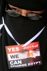 An Egyptian woman protests at Tahrir Square, Cairo. The Arabic on the card reads: ''Martyrs of January 25''.