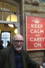 Stuart Manley with the poster he found at the bottom of a box of books and began selling in his second-hand bookshop.