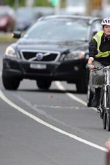A cyclist navigates her way through traffic on St Kilda Road.