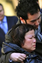 Thay Huynh is comforted by her son, Frankie, as they leave court.