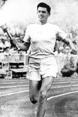 Ron Clarke carries the Olympic flame during the 1956 opening ceremony at the MCG.