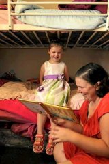 Kelli Hobson reads to her daughter Emma, 4.