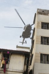 Commandoes get down from a chopper to the roof of a house owned by Israelis in Colaba, Mumbai.