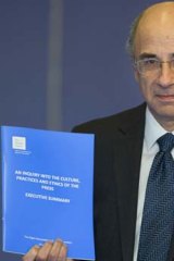 Lord Justice Leveson poses with a summary of the Leveson Report.