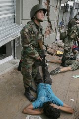Emergency force ... Chilean soldiers detain alleged looters in Concepcion.