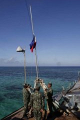 Philippines Marines salute their country's flag after the changing of the guard on board the Sierra Madre.