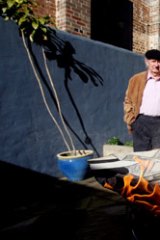 Artists Charles Blackman and Robert Dickerson burning fake paintings purporting to be their works.