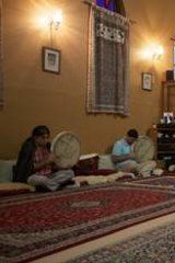 Brad Warren (in white shirt) plays a sarod at the House of Sufism in Balmain.