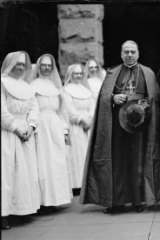 Archbishop Mannix and Cardinal Carretti standing with a group of nuns, New South Wales, circa 1930.