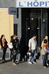 Job seekers line up at an employment office in Madrid.