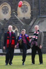Archbishop of Perth Roger Herft gets a fine punt away, watched by Melbourne Archbishop Philip Freier (left) and auxiliary archbishop of Melbourne Paul White before the opening of the synod yesterday.