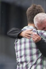 A young survivor embraces his father.