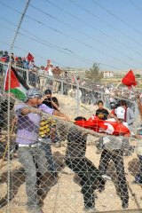 Palestinian, foreign and Israeli left-wing activists try to break down a section of Israel's separation barrier.