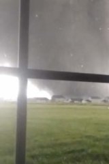 An active tornado is seen through a window as it touches down in Washington, Illinois, in this still image captured from a video courtesy of Anthony Khoury.