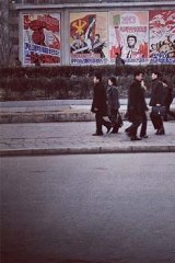 Commuters pass by propaganda posters in Pyongyang.