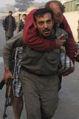 Nine dead, nine injured ... police carry a survivor of the Kabul guesthouse attack, the Taliban’s first step in a campaign against Afghanistan’s run-off  election.