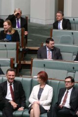 Target: Kevin Rudd peers at Julia Gillard from the backbench this month.