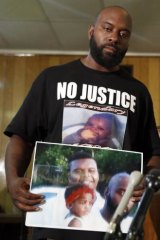 Michael Brown snr holds up a photo of himself with his son, Michael Brown.