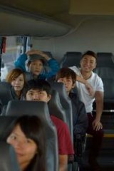 A group of Chinese tourists travel on a bus tour of the Great Ocean Road.