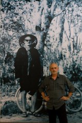 George Burchett in front of a photograph of Willfred at the exhibition in Hanoi.