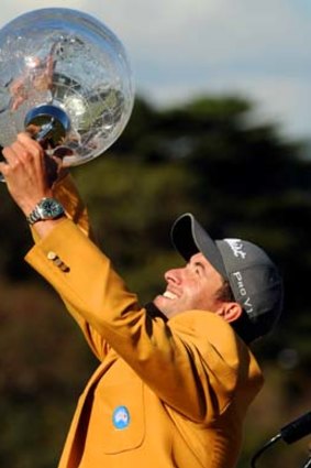 Adam Scott holds the trophy aloft.