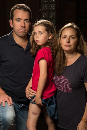 Madeleine Danaher, with parents Tom and Lorelie, shows the scar from her ulcer.