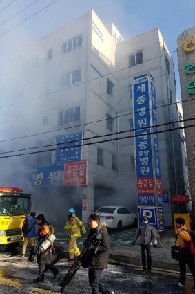 Firefighters work as smoke billows from a hospital in Miryang, South Korea