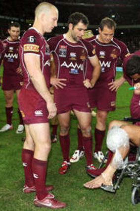 Origin flashback 2011: Darren Lockyer, Cameron Smith and Matt Scott speak to Johnathan Thurston in a wheelchair after injuring his knee during game three of the State of Origin series.