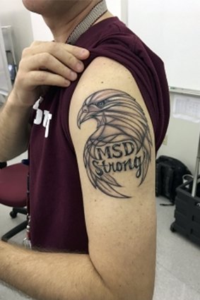 Frank Krar, a statistics teacher at Marjory Stoneman Douglas High School displays his new tattoo in the campus, to honour of the victims of the shooting at the school, in Parkland, Florida.