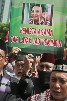Muslims protesters hold up a poster depicting Jakarta Governor 'Ahok' behind bars. 