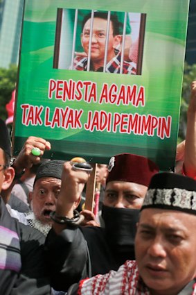 Muslims protesters hold up a poster depicting Jakarta Governor 'Ahok' behind bars. 