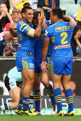 The Eels congratulate Ryan Morgan after he scores during the first half.