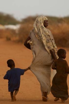 Footsteps in the dust ... a woman and her children walk along a road on the outskirts of Dadaab refugee camp.