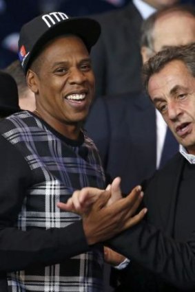 Former French president Nicolas Sarkozy shakes hands with rapper Jay-Z.