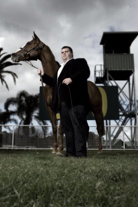 Mining magnate Nathan Tinkler poses at Randwick Racecourse with one of his mares.
