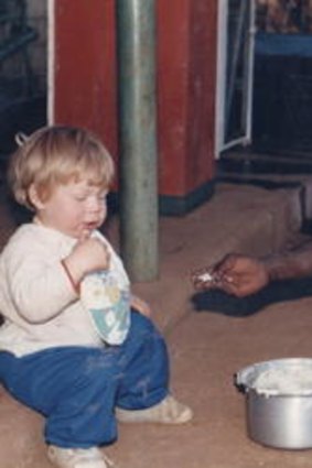 A young David Pocock eats sadza (a local dish) with a family farm worker in Zimbabwe.