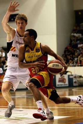 Patty Mills of the Tigers drives past Cameron Tovey of the Perth Wildcats.