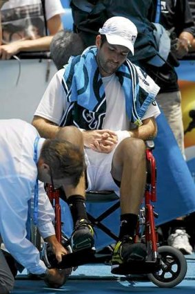 Brian Baker is assisted onto a wheelchair.
