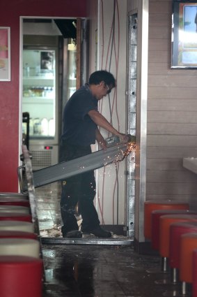 Workers repair damage to McDonald's Braddon restaurant following explosion. 