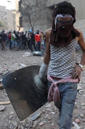 A protester protects himself during clashes with riot police near Tahrir Square in Cairo.