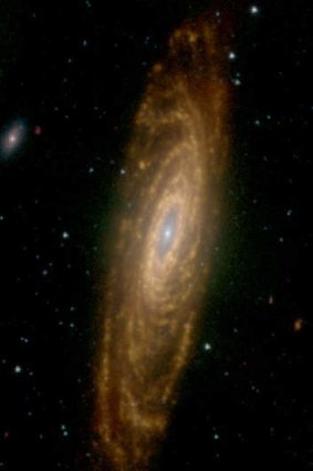 Galaxy NGC 7331 with a red glow coming from dust heated by hot stars.