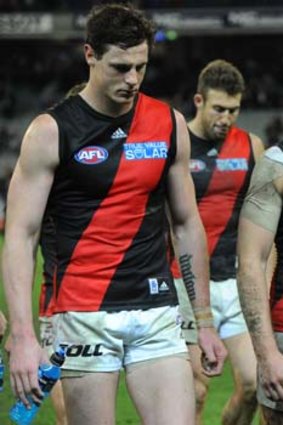 Digesting the bad news: Essendon's Jake Carlisle and Jobe Watson leave the ground after being mauled by Collingwood.