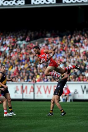 Flying &#8230; the good moments like this screamer from Adam Goodes over Bachar Houli were too few for the Swans.