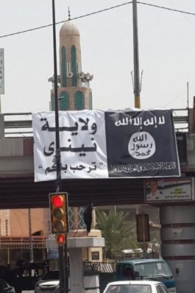 New state: the jihadist banner flies over a major intersection in Mosul.