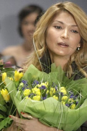 Gulnara Karimova holds flowers at the end of a parade.