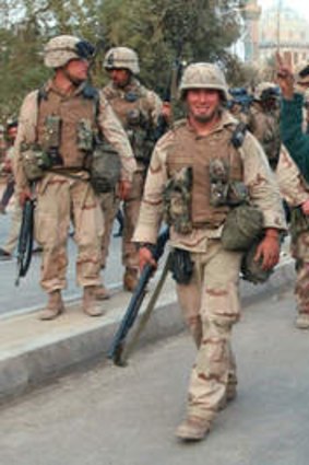 A jubilant boy joins US troops entering Baghdad in 2003.