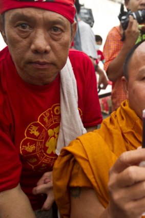 A Buddhist monk shows his blood after making a blood donation.