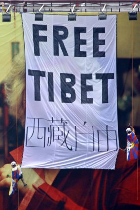 Pro-Tibet activists, including Australian Nicole Rycroft, unfurl a "Free Tibet" banner over an Olympics billboard in Beijing yesterday.