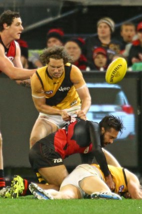Tiger Ty Vickery looks on anxiously as Courtenay Dempsey of Essendon slings Brett Deledio of Richmond to the ground.